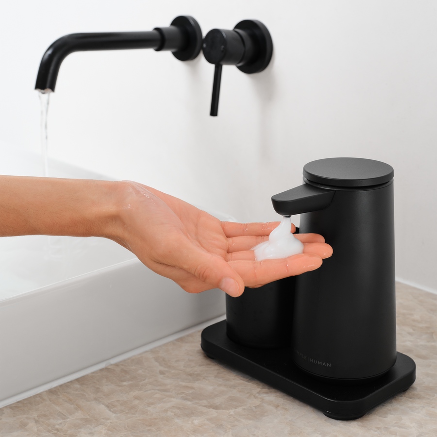 Simplehuman Matte Black touch-free Foam Sensor Pump and Cup dispensing foam into a hand.
